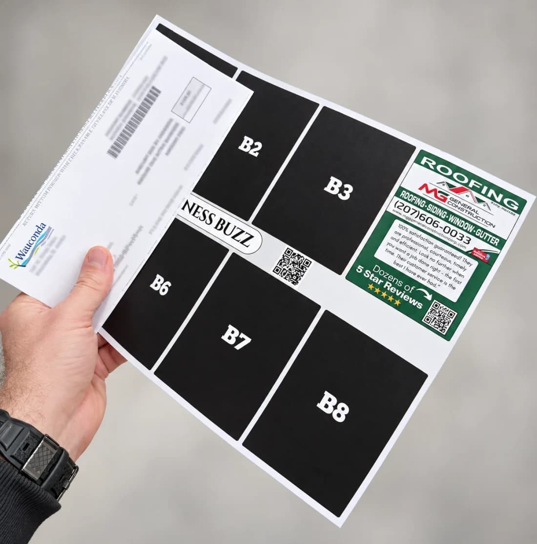 A hand holding a printed 9 by 12 inch shared postcard on top of a standard business envelope, showing several ad spaces and one finished advertiser ad.